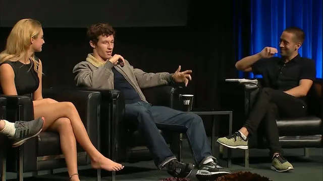 Grace Van Patten sitting with her legs crossed during a panel.