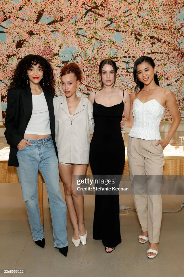 Adelaide Kane standing with companions beside an event backdrop.