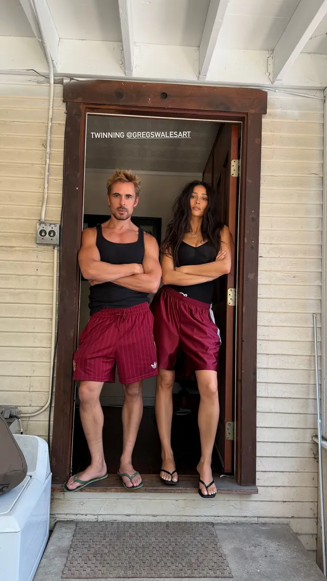 Shay Mitchell standing beside a companion in a doorway.